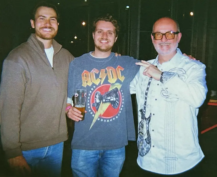 Three Vidsy friends posing on a night out, one wearing an AC/DC t-shirt